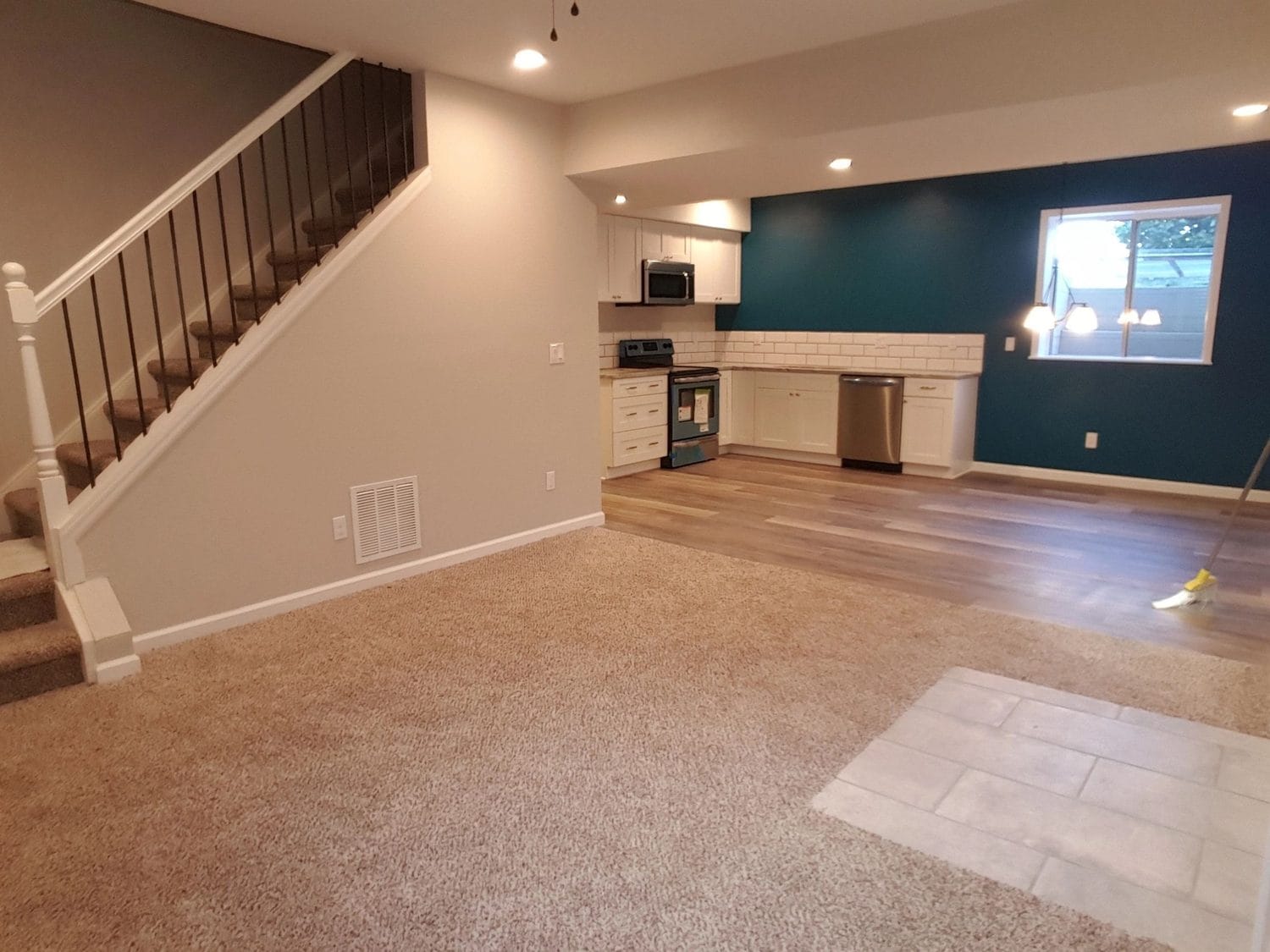 A finished lower level with a new stair and a painted accent wall