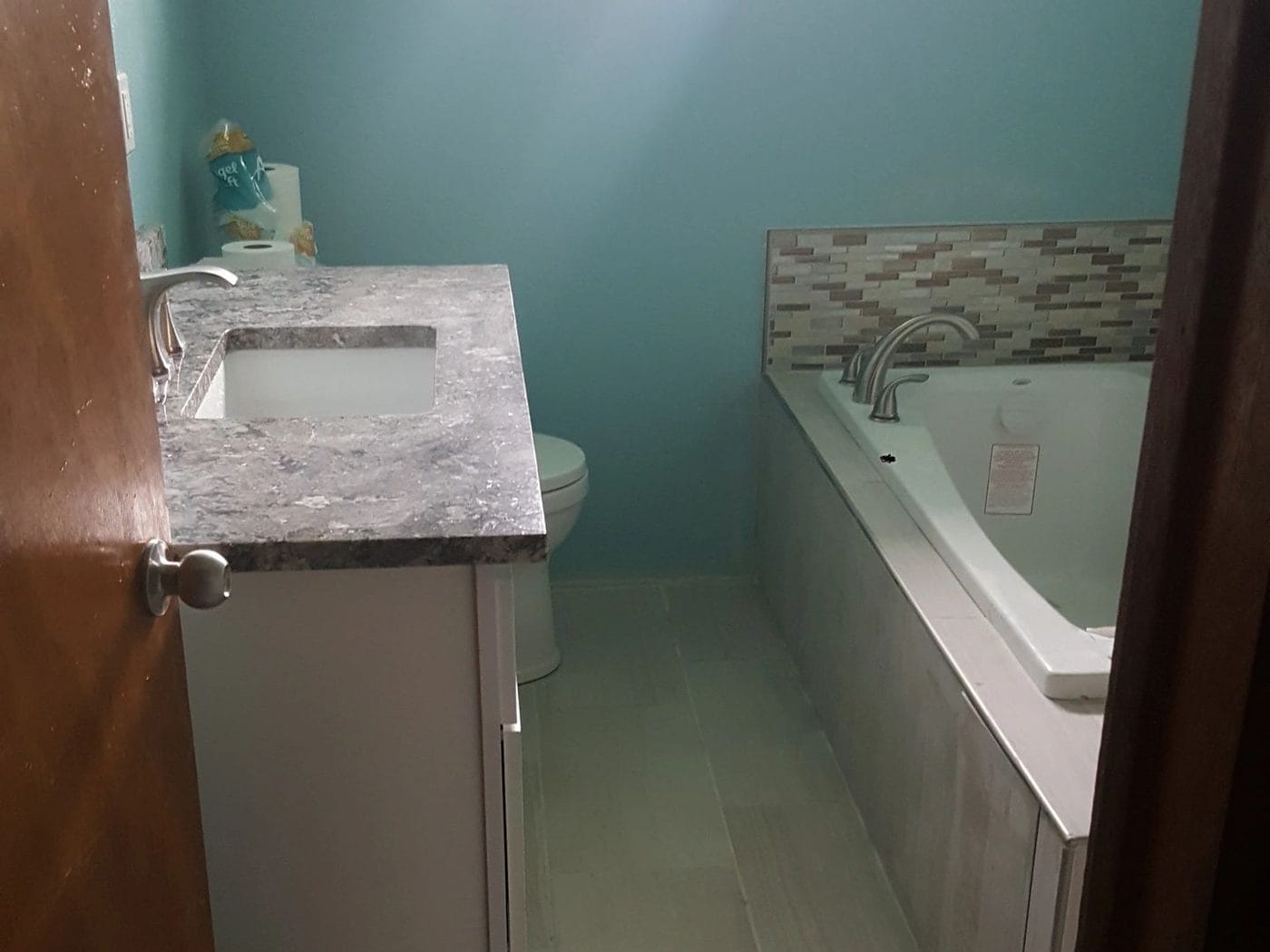 Stone vanity top run alongside a drop-in tub