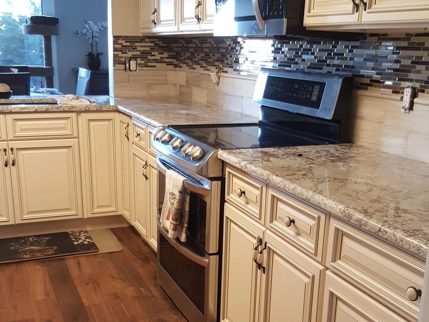 A finished kitchen with cream cabinetry and granite counters