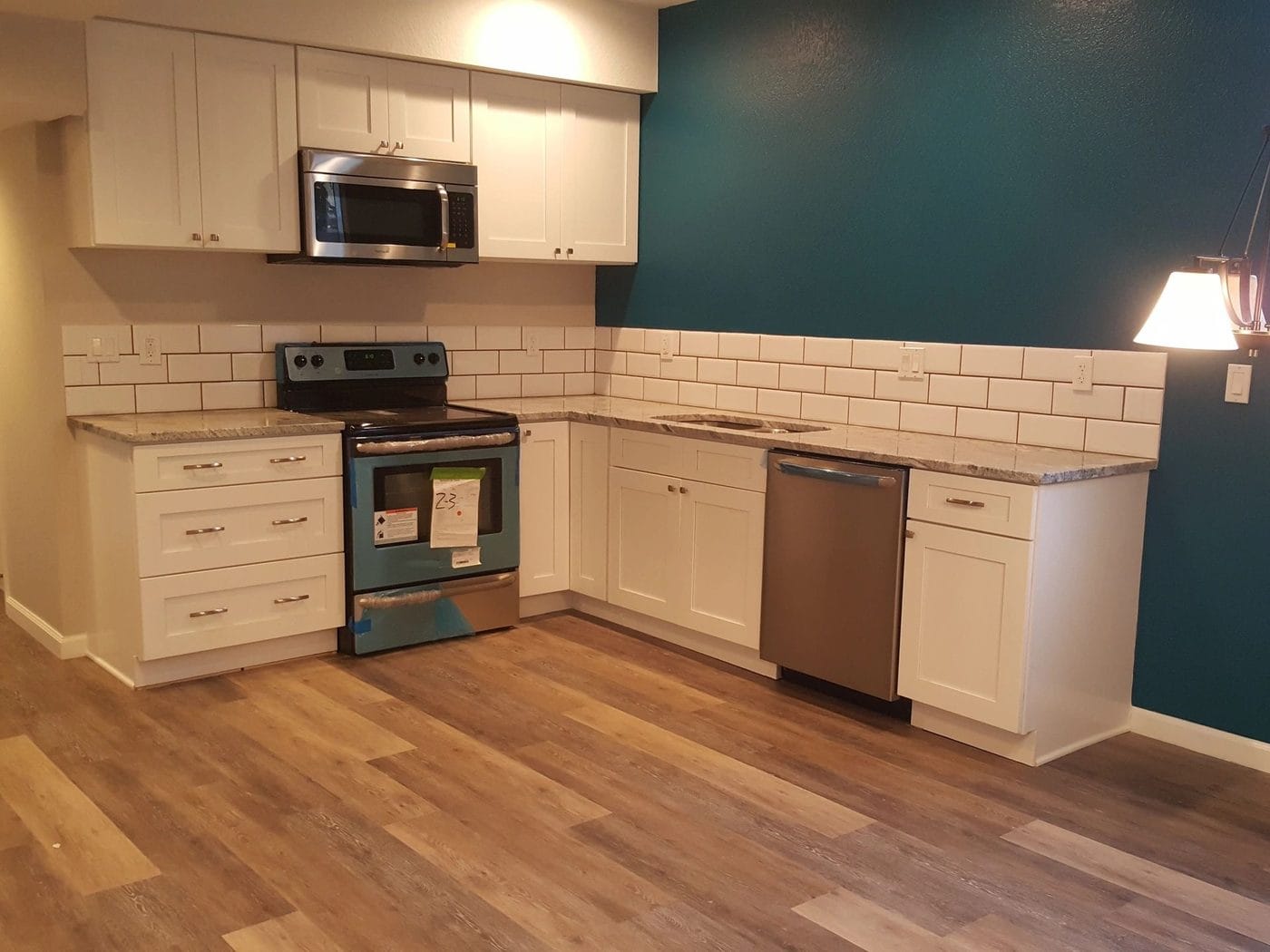 A kitchen with white shaker cabinetry and a subway tile backsplash