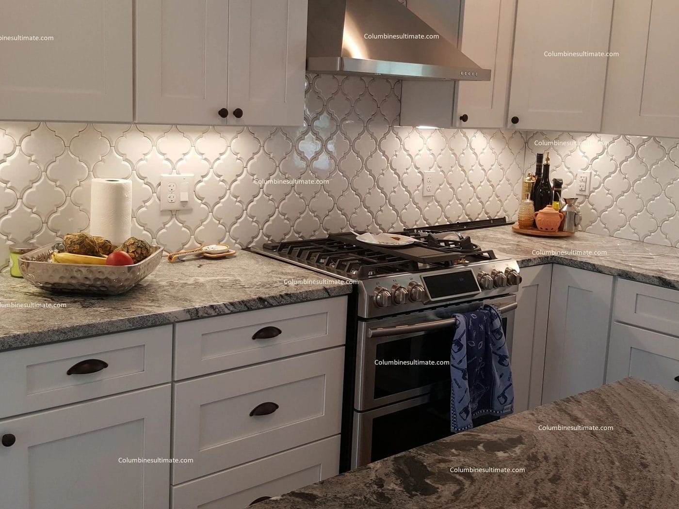 A kitchen with an arabesque tile backsplash and a gas range